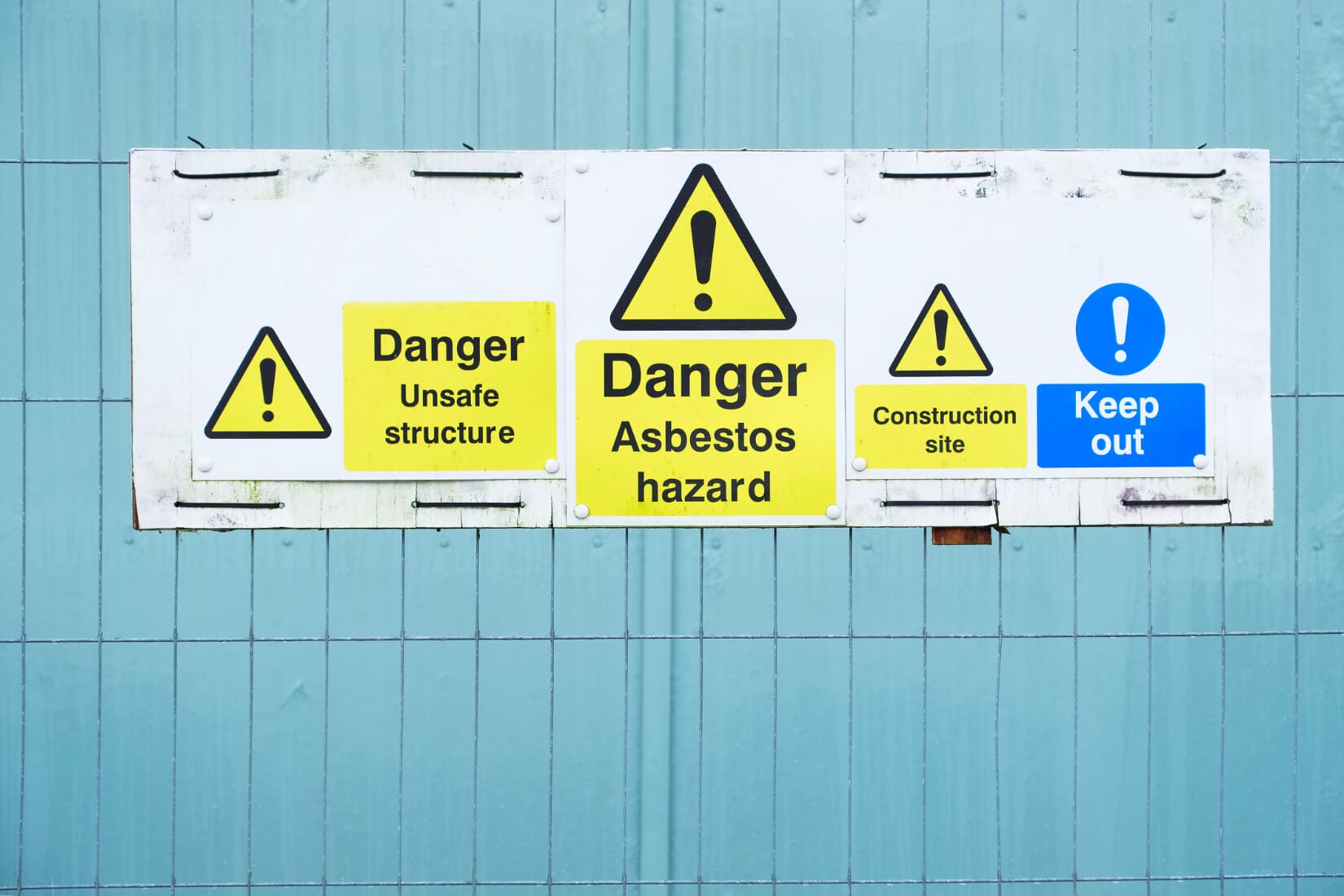 Asbestos hazard danger sign at construction site keep out.
